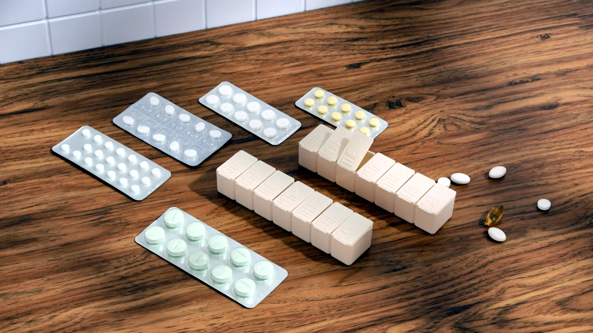A small plastic blister pack of round white pills lying on a pale blue bathroom table.