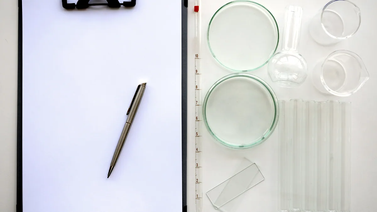 A printed lab report lying on a white desk next to a pen and a small glass of water.